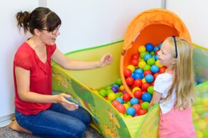 A young therapist practicing synergetic play therapy with a toddler girl in Keller, TX